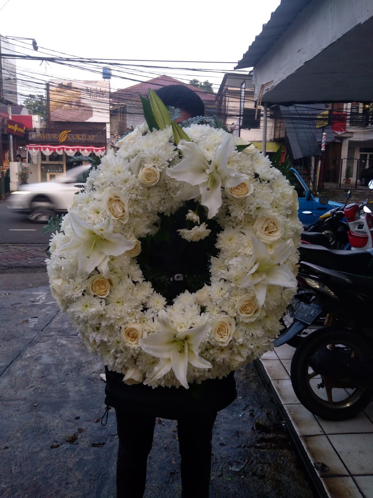 Karangan bunga bulat buat di atas peti